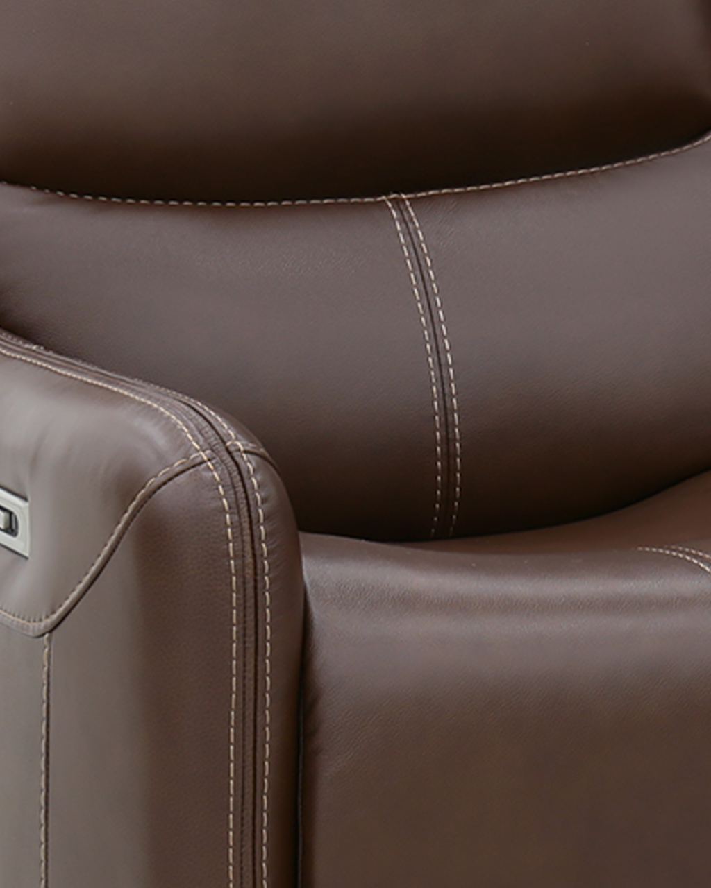 Close-up of a brown top-grain leather sofa arm and headrest, showing the grain, the welt and the contrast stitching.