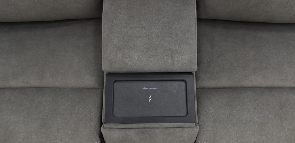 Drop-down console on a fabric sectional revealing an integrated wireless charging pad.