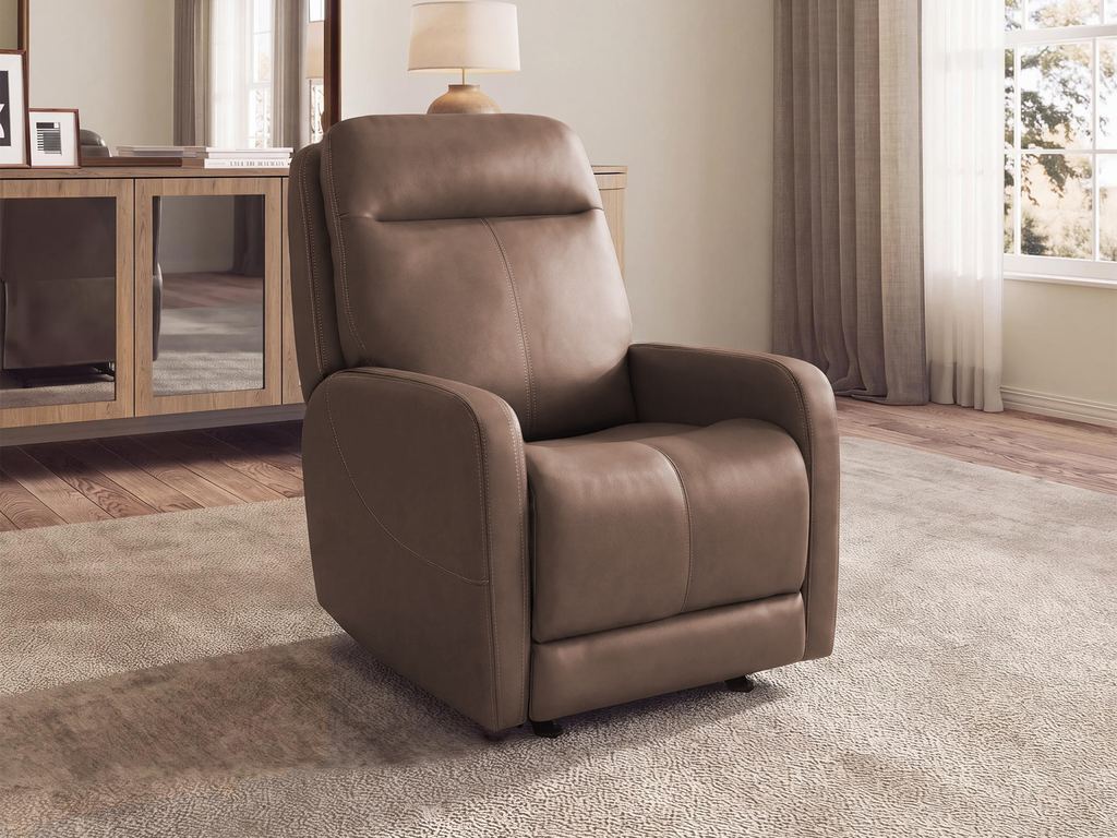 A taupe power recliner in a warm room with a table lamp, a wooden sideboard and a soft rug.